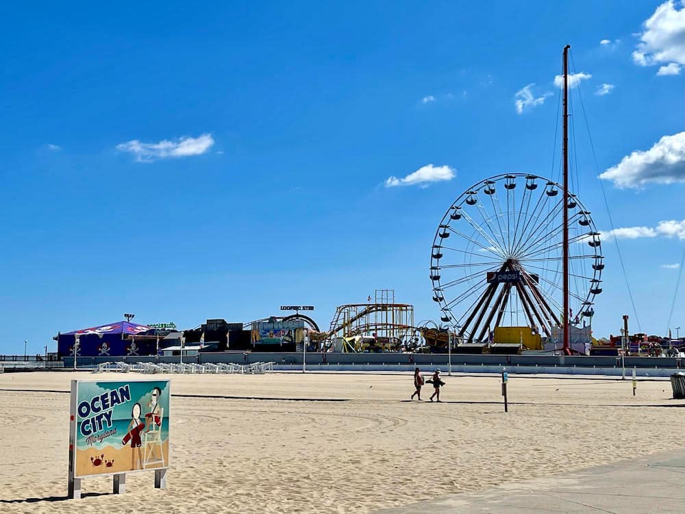 A ferris wheel, sandy beach, and carnival rides in Ocean City, Maryland