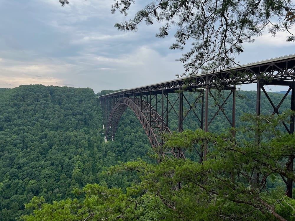 The New River Gorge Bridge running through the green forest in West Virginia.