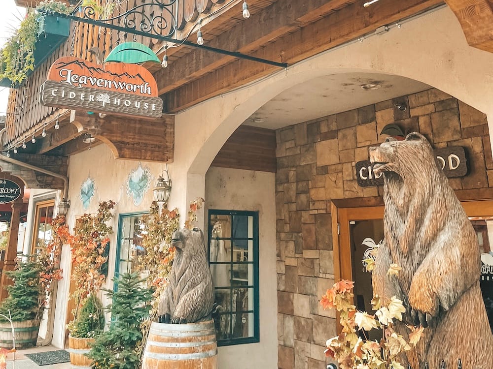 The outside of Leavenworth Cider House with two bear statues out front.