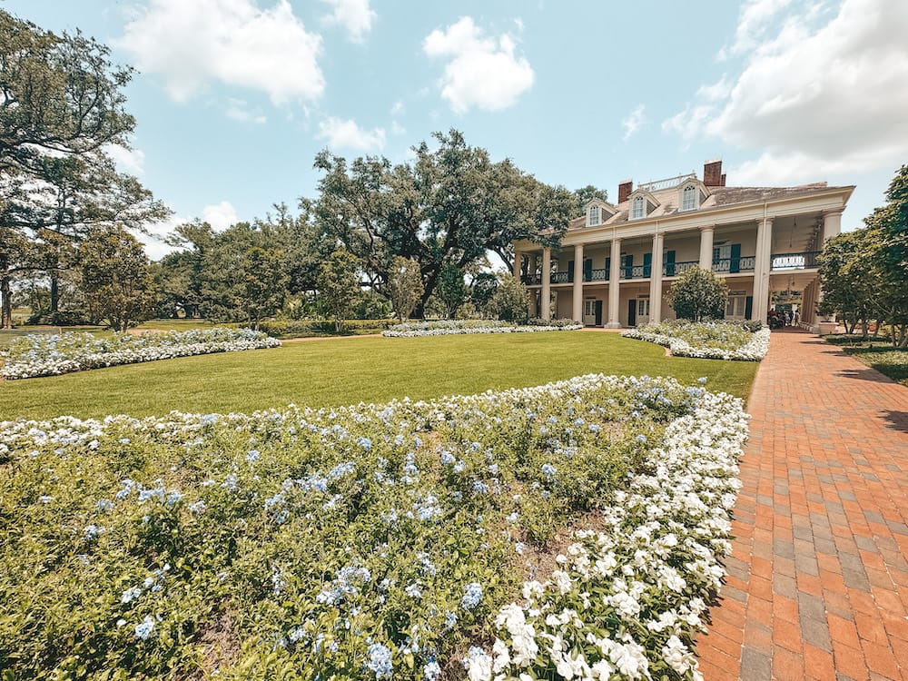 The West Garden at Oak Alley Plantation, filled with blue and white flowers on the west side of the Big House.