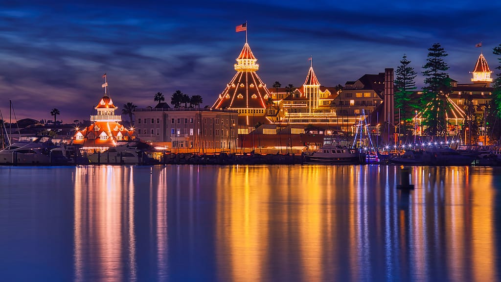 The Hotel Del Coronado lit up for the holidays and reflected into the ocean at night.