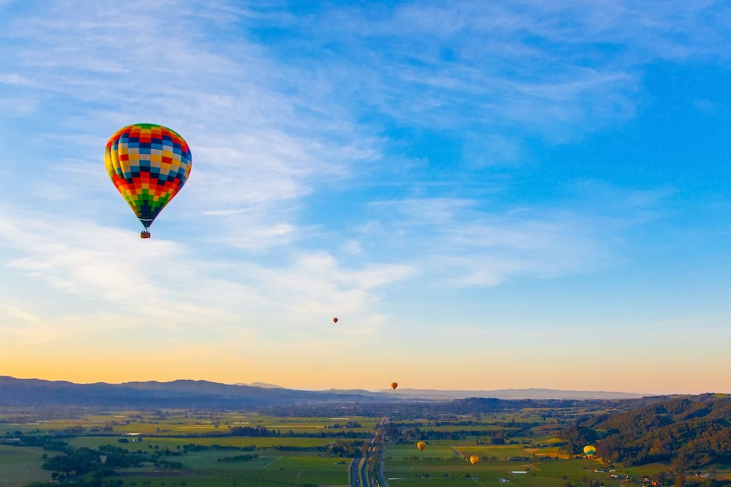 A hot air balloon soaring over the wine country in Napa Valley, one of the best places to visit in February in the USA