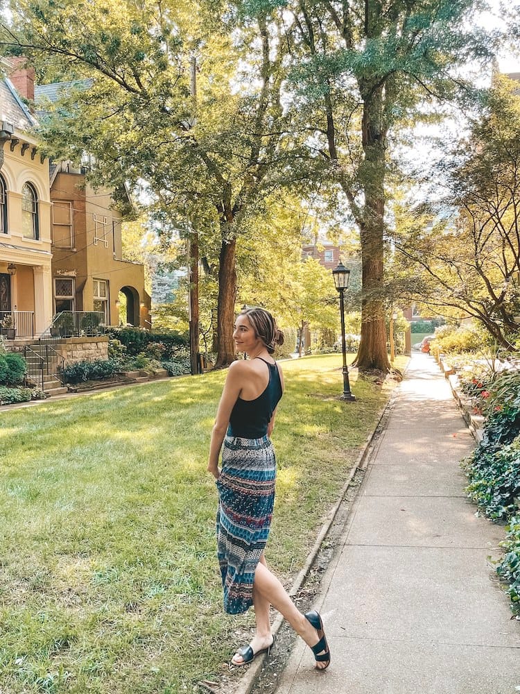 Weekend in Louisville - Woman standing in a courtyard with lamposts, grass, trees, and historic houses - Travel by Brit