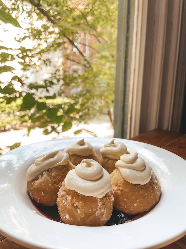A bowl of five biscuit donuts with cream cheese frosting at Biscuit Love, one of the most fun places to eat in Nashville