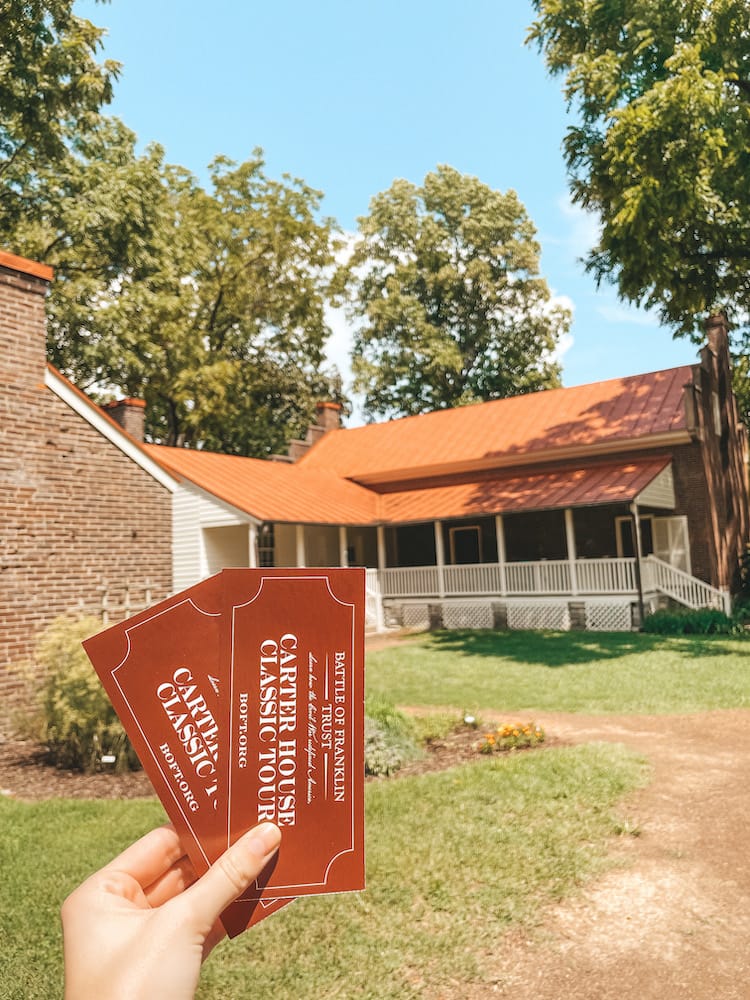Two red tickets to the Carter House Tour in front of the Carter House, one of the best things to do in Franklin, TN
