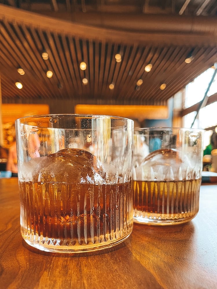 Two old fashioned drinks sitting on a table in the Starbucks Reserve Roastery in Seattle.