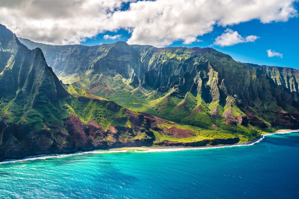 The coast of Kauai with lush green mountains and blue water