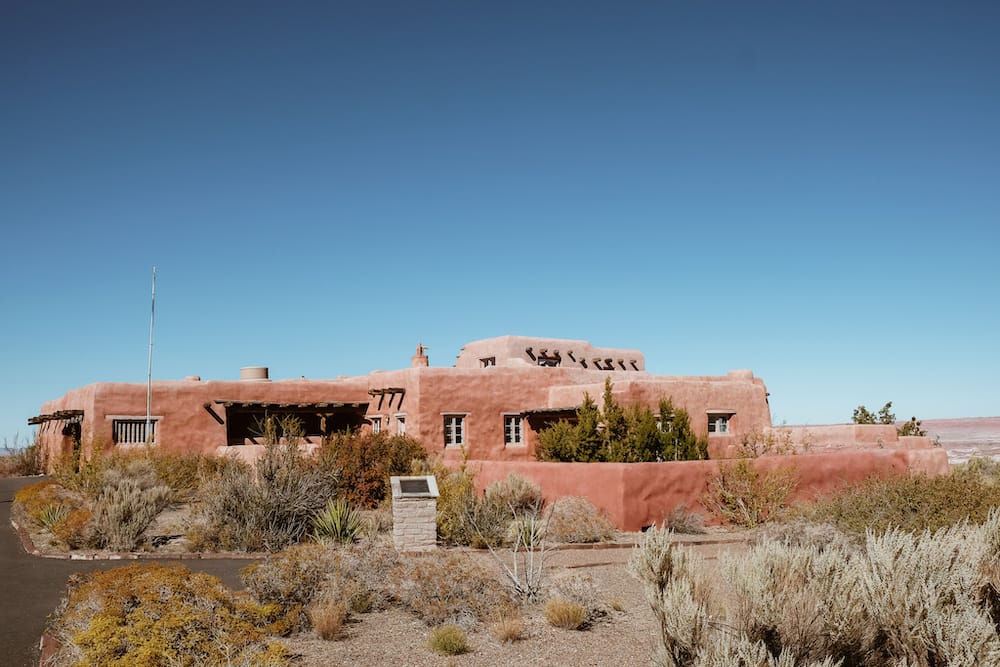 A red adobe-style building surrounding by desert plants in Petrified Forest National Park – one of the best day trips from Sedona.