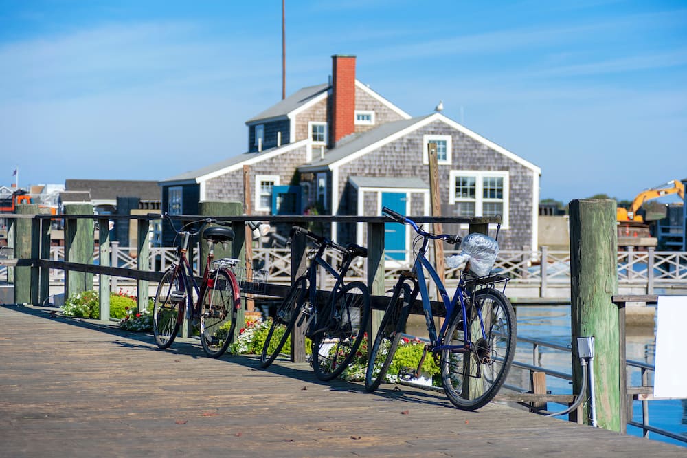 Several bikes along the water on a bridge in Nantucket, one of the best places to visit in the USA in July.