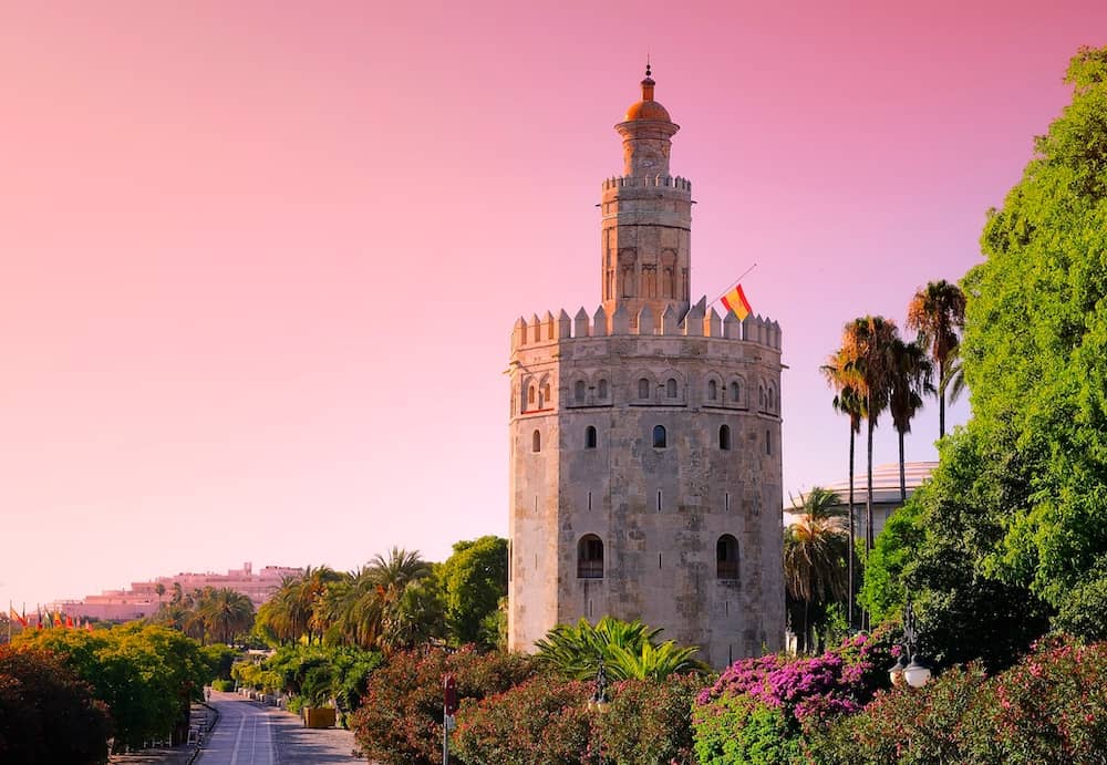 A old, historic tower against the pink sky at sunset in Seville, Spain – one of the best free things to do in Seville