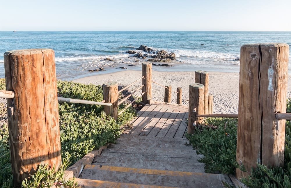 A set of wooden stairs leading down to a beach in Carpinteria